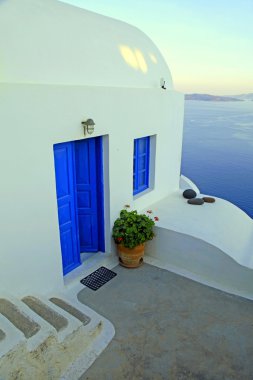 White house with blue windows in traditional village Oia, Santor