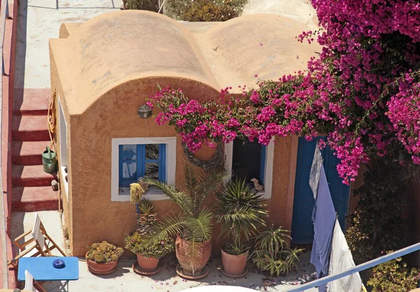 Græsk rød bygning med terrasse og blomster, Santorini ø, Gr - Stock-foto