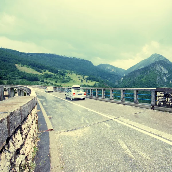 Αυτοκίνητο και διασχίζουν τη γέφυρα πάνω από τον ποταμό Τάρα, Ντούρμιτορ εθνικό πάρκο, Μαυροβούνιο — Φωτογραφία Αρχείου