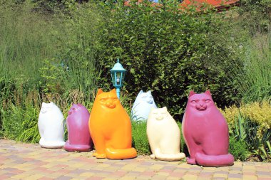 Çok renkli seramik kedi heykeller bahçedeki