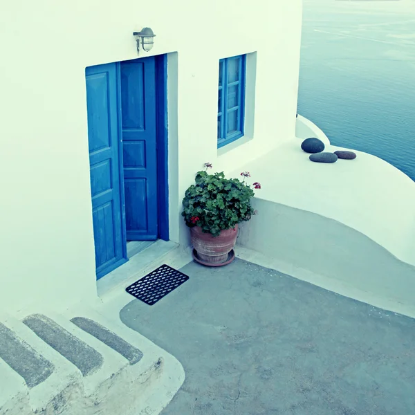 Белый дом с голубыми окнами в традиционной деревне Ия, Санторини — стоковое фото