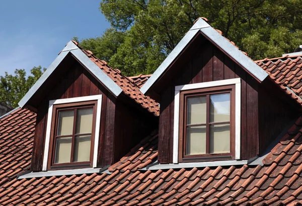 Oranje betegeld dak en garret windows in oud huis — Stockfoto