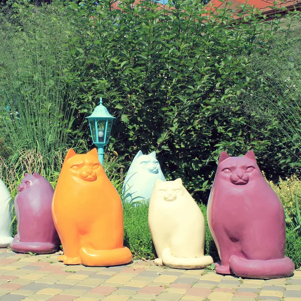 Multicolor keramische kat standbeelden in de tuin — Stockfoto