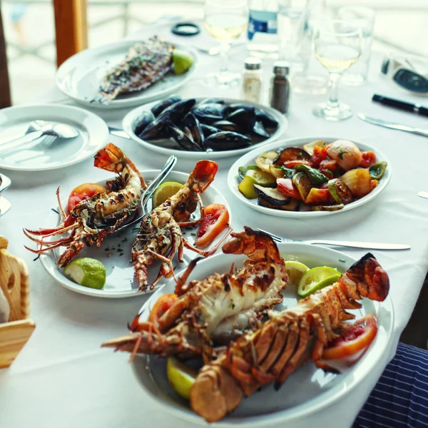 Lobster and vegetables an the table in typical greek taverna, Cr — Stock Photo, Image