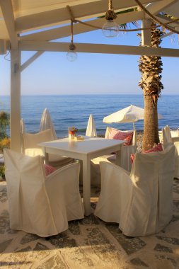 Beyaz masa ve sandalyeler deniz kenarı, Crete, Yunanistan. 