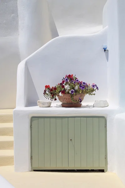 Weißes Haus und Vase mit Blumen in Santorini, Griechenland. — Stockfoto
