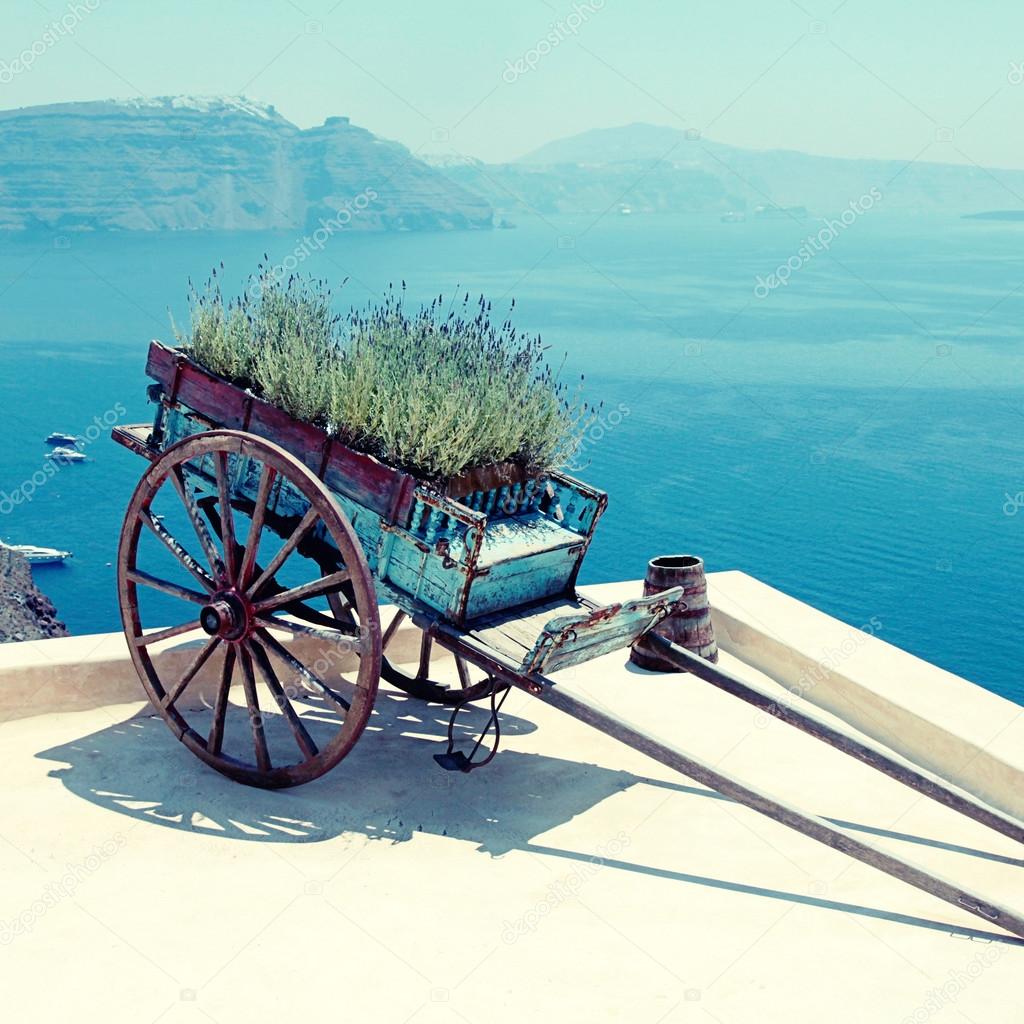 Decorative old cart with flowers on terrace, Santorini, Greece.