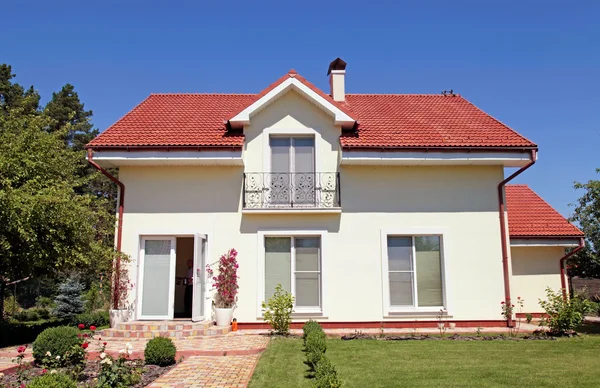 Witte huis met groen gazon en blauwe hemel — Stockfoto