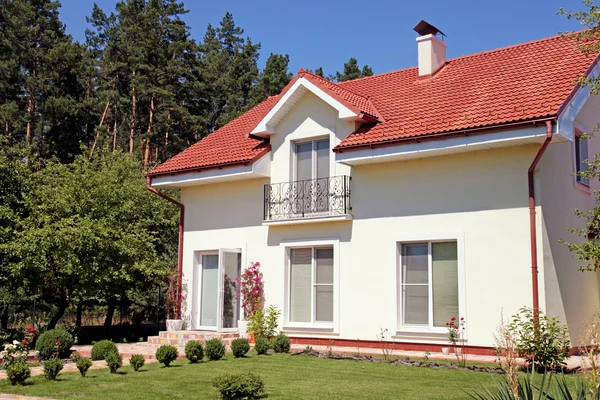 Casa branca com gramado verde e céu azul — Fotografia de Stock