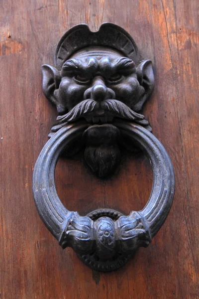 Antique door knob with man's head on old wooden obsolete door — Stock Photo, Image