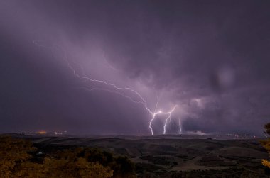 Beautiful night sky with lightning and thunderbolts during a thunderstorm in the countryside clipart