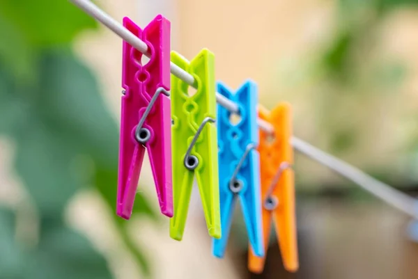 Colored clothespins hanging by a thread