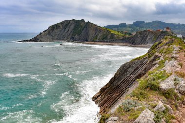 Flysch rock formations in the Basque Coast UNESCO Global Geopark between Zumaia and Deba, Spain clipart