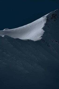 Arkhyz kayak merkezinin kuzey yamacındaki Arkasara sırtı. Kış manzarası. Koyu mavi gökyüzüne karşı beyaz, karlı bir dağ. Dağ arazisi zıt. Arkaplan ve duvar kağıdı.