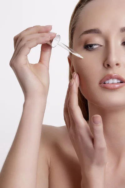 Closeup of a beautiful woman applying a beauty treatment — Stock Photo, Image