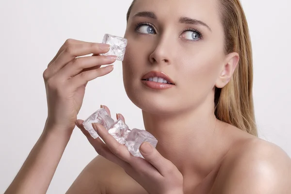 Hermosa mujer aplicando tratamiento de cubo de hielo en la cara —  Fotos de Stock