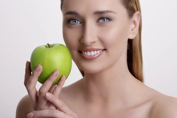 Färska unga kvinnan visar ett grönt äpple — Stockfoto