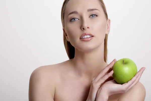 Verse jonge vrouw toont een groene appel — Stockfoto