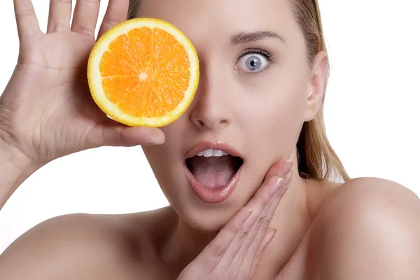 Bella ragazza felice che mostra un arancio succoso — Foto Stock