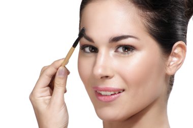 Güzel genç kadın kaş fırçası uygulamak