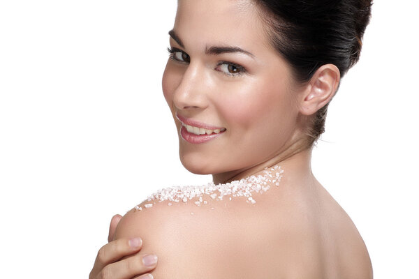 Красивая молодая женщина наносит скраб на кожу
 