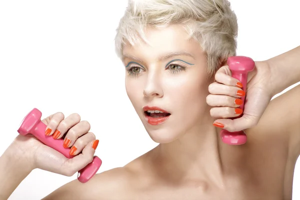 Hübsches junges Model spielt mit rosa Hanteln — Stockfoto
