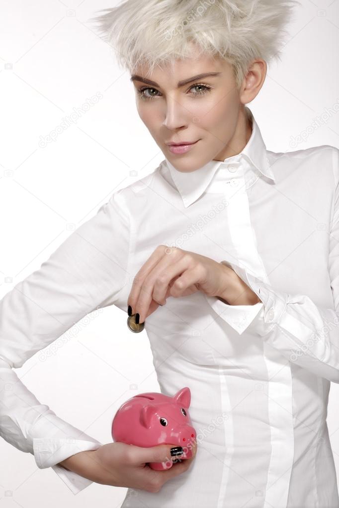 business woman put a coin on a pink piggybank 