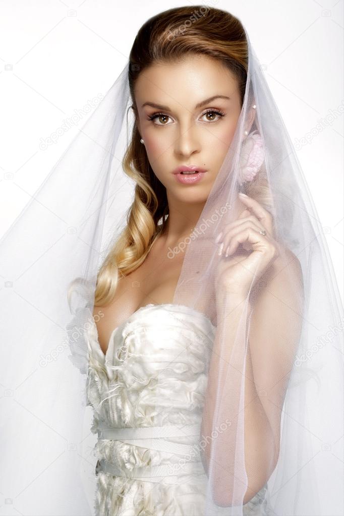 portrait of  young woman in wedding dress posing with white brid