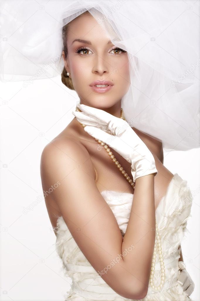 portrait of  young woman in wedding dress posing with white brid