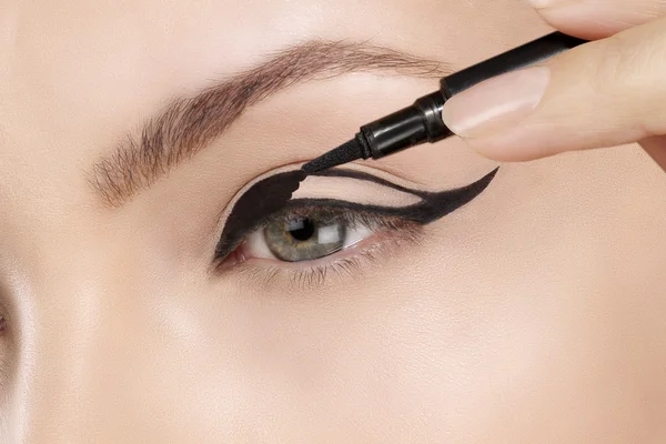 Schönes Modell, das Eyeliner-Nahaufnahme auf Auge aufträgt — Stockfoto