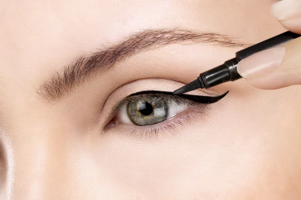 Bellissimo modello applicando eyeliner primo piano sugli occhi Fotografia Stock