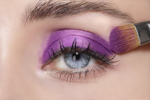 Close up on eyes , making colorful eyeshadows and eyeliner — Stock Photo, Image