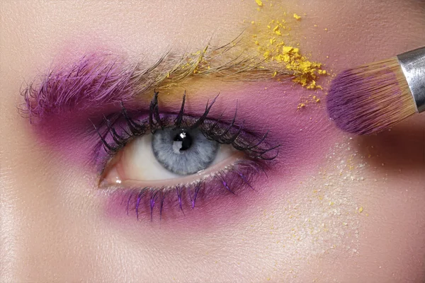 Primo piano sugli occhi, facendo ombretti colorati e eyeliner — Foto Stock