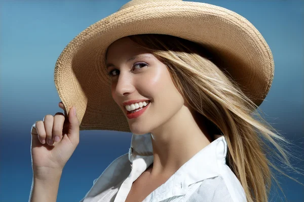 Menina loira natural sorrindo usando um chapéu na praia — Fotografia de Stock