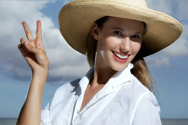 Chica rubia natural sonriendo con un sombrero en la playa — Foto de Stock