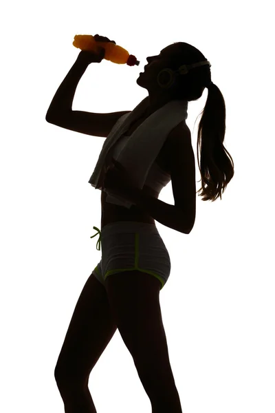 Eine Frau beim Fitness-Trinken von Energy Drink in Silhouette lizenzfreie Stockfotos