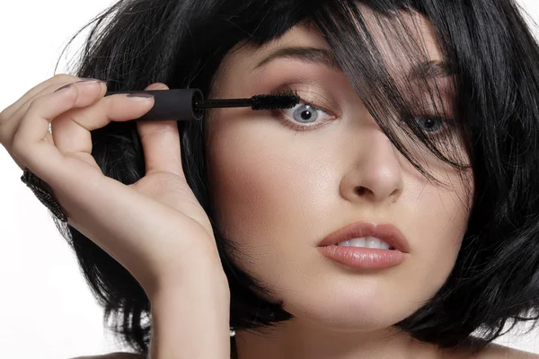 Joven hermosa mujer aplicando maquillaje de rímel en los ojos por cepillo — Foto de Stock