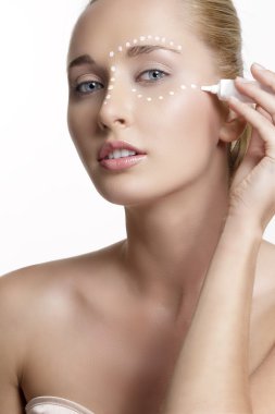 genç güzel kadın derisinin üzerinde krem uygulamak