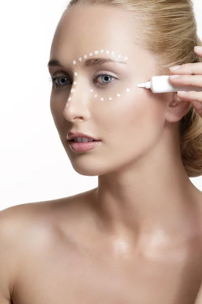 Joven hermosa mujer aplicando crema en su piel —  Fotos de Stock