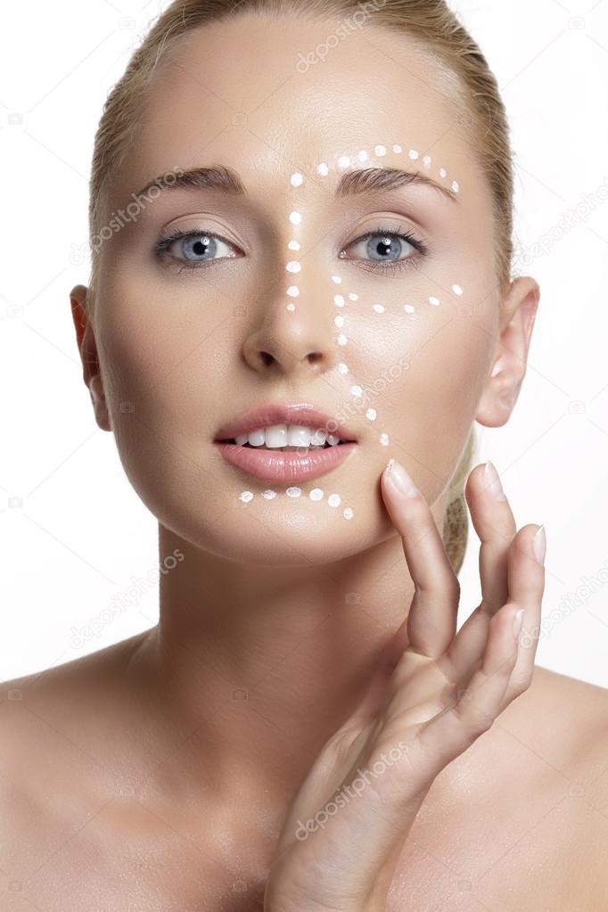 young beautiful woman applying creme on her skin