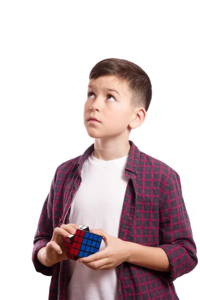 Um rapaz com um cubo de Rubik nas mãos — Fotografia de Stock