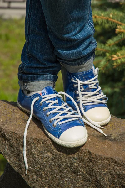 Legs in sneakers on the stone — Stock Photo, Image