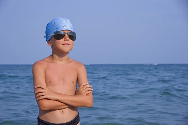 Boy in sunglasses and a bandana on the sea — Stock Photo, Image