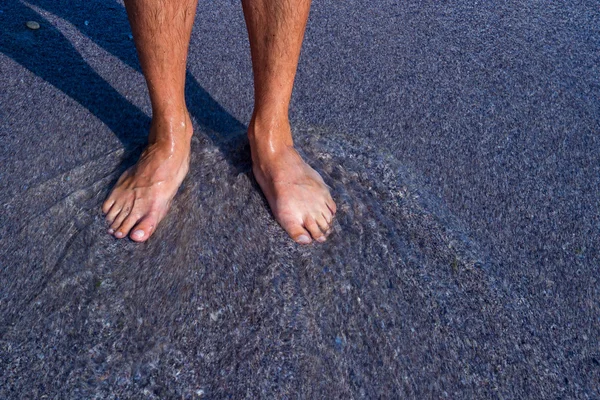 Men's feet on the pebbles — Stock Photo, Image