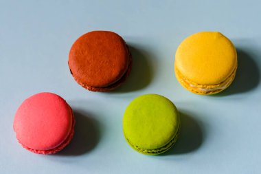 Mavi arka planda dört renkli badem kurabiyesi.