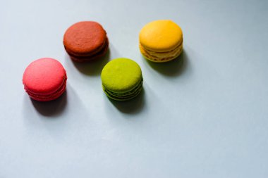 Mavi arka planda dört renkli badem kurabiyesi.