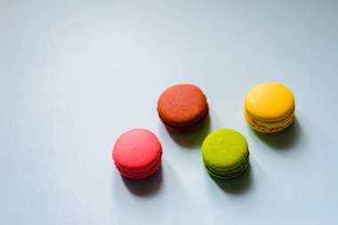 Mavi arka planda dört renkli badem kurabiyesi.