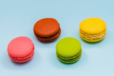 Mavi arka planda dört renkli badem kurabiyesi.