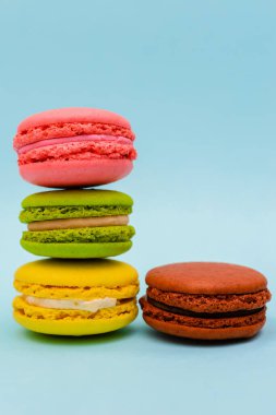 Mavi arka planda dört renkli badem kurabiyesi.