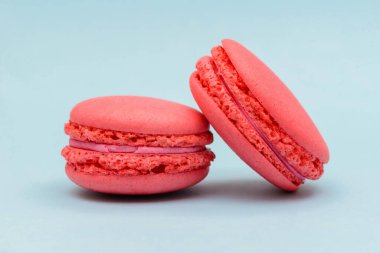 Mavi arka planda iki pembe makarna keki.